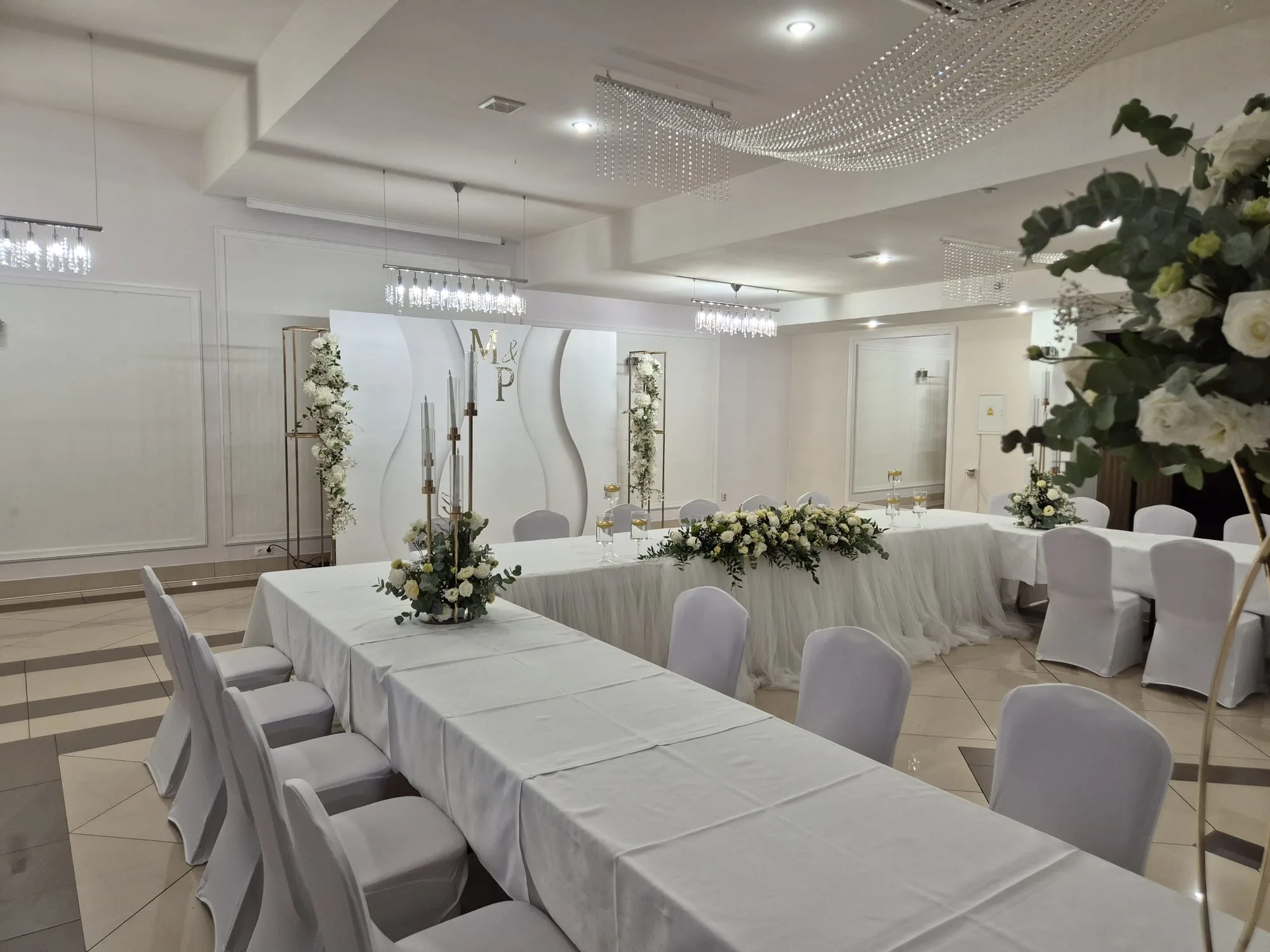 Dekoracja z inicjałami pary młodej i kwiatami, wesele w Restauracji Szkiełka