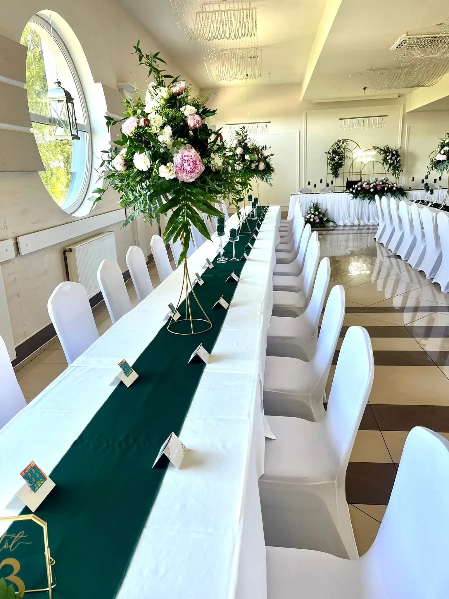 Stół weselny z wysokimi kompozycjami kwiatowymi w zieleni butelkowej, Restauracja Szkiełka