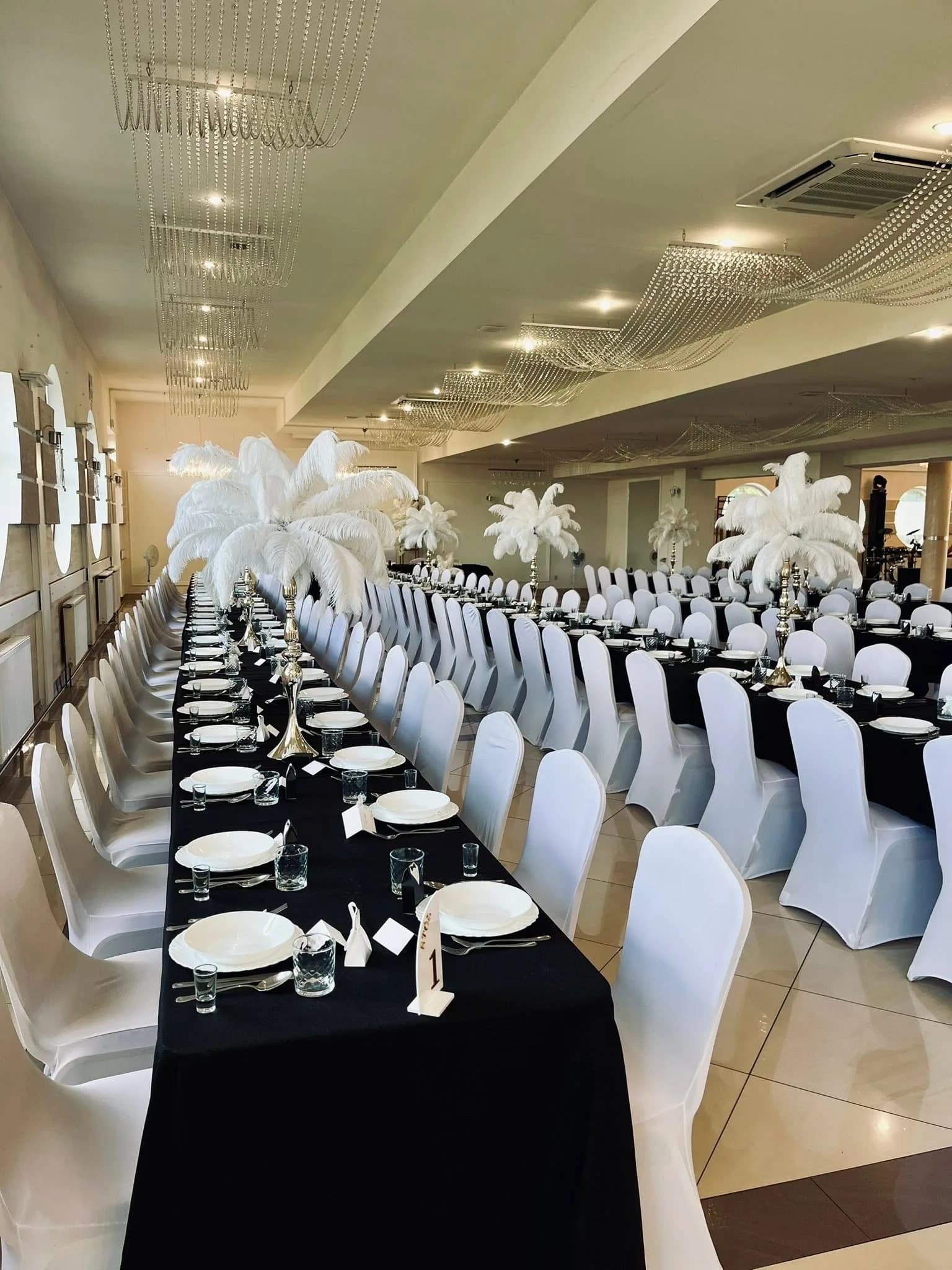 Sala weselna w czarno-białej stylizacji z piórami strusimi i numeracją stołów, Restauracja Szkiełka
